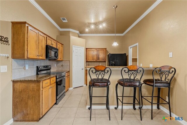 308 Constellation Dr, Killeen, TX 76542 - kitchen with black appliances, a peninsula, a breakfast bar area, brown cabinetry, and tasteful backsplash
