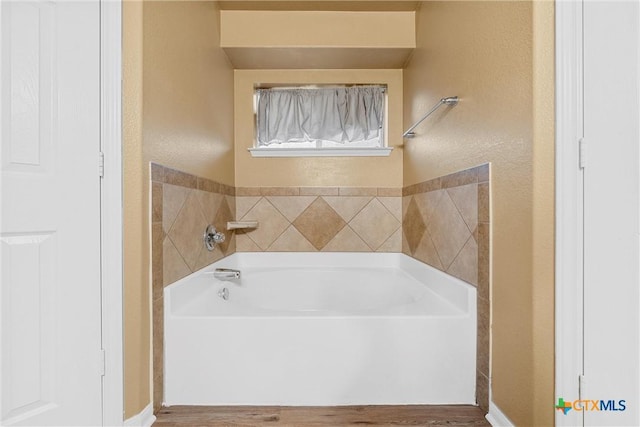 308 Constellation Dr, Killeen, TX 76542 - bathroom with a bath, a textured wall, wood finished floors, and baseboards