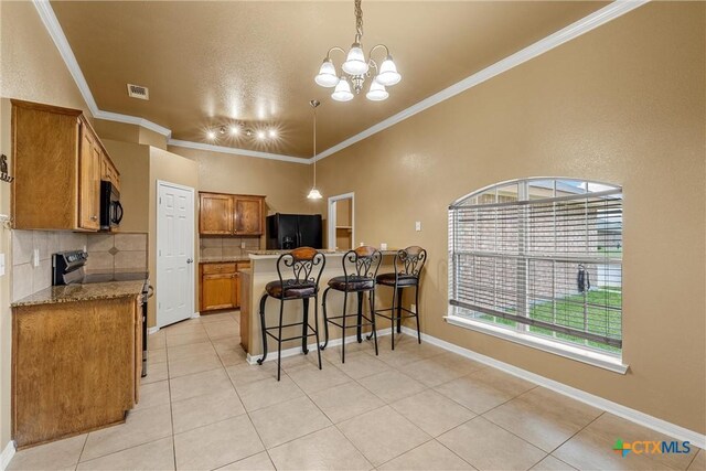 308 Constellation Dr, Killeen, TX 76542 - kitchen with black appliances, brown cabinets, backsplash, light tile patterned flooring, and a breakfast bar