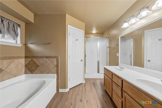 308 Constellation Dr, Killeen, TX 76542 - full bath featuring a bath, wood finished floors, double vanity, and a stall shower