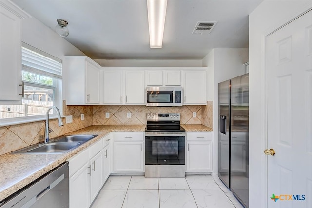 5500 Lions Gate Ln, Killeen, TX 76549 - kitchen featuring appliances with stainless steel finishes, light marble finish floors, white cabinetry, and light countertops
