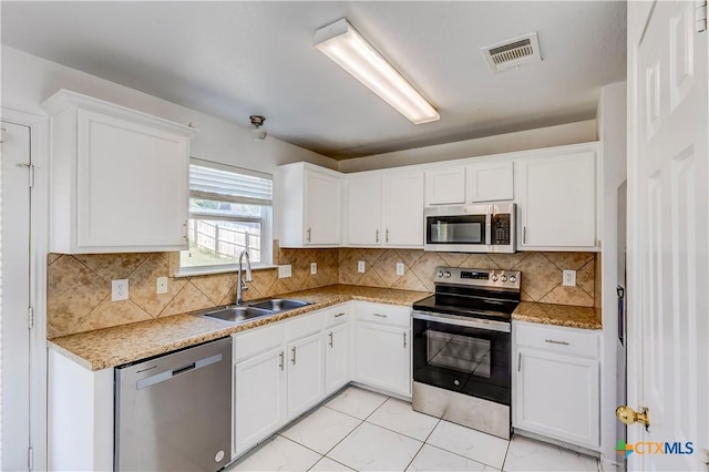 5500 Lions Gate Ln, Killeen, TX 76549 - kitchen with appliances with stainless steel finishes, white cabinets, decorative backsplash, and light stone counters