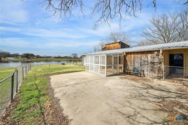 exterior space featuring an outdoor structure, fence, and a water view