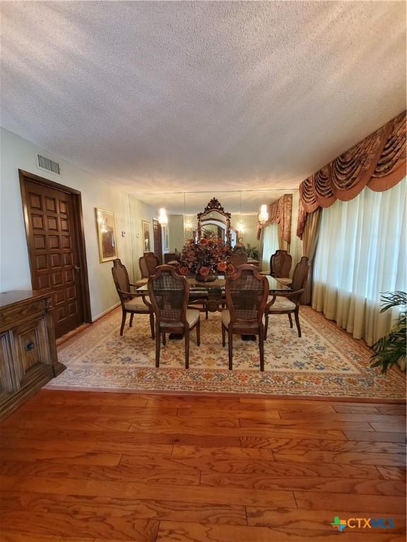 313 N Church, Goliad, TX 77963 - dining room featuring a textured ceiling and light wood finished floors