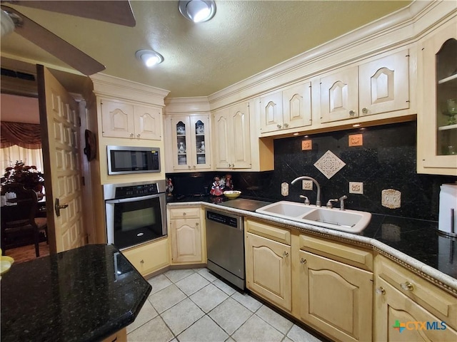 313 N Church, Goliad, TX 77963 - kitchen featuring stainless steel appliances, a sink, light tile patterned floors, decorative backsplash, and crown molding