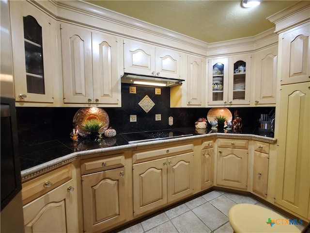 313 N Church, Goliad, TX 77963 - kitchen with under cabinet range hood, light tile patterned floors, black electric cooktop, and glass insert cabinets