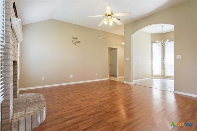 4103 Barrington Trl, Killeen, TX 76549 - unfurnished living room featuring lofted ceiling, a fireplace, wood finished floors, a ceiling fan, and arched walkways