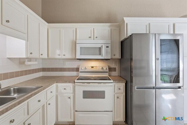 4103 Barrington Trl, Killeen, TX 76549 - kitchen featuring white appliances, white cabinetry, tasteful backsplash, and light countertops