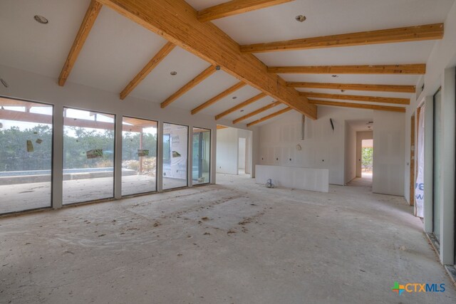 unfurnished living room featuring lofted ceiling with beams