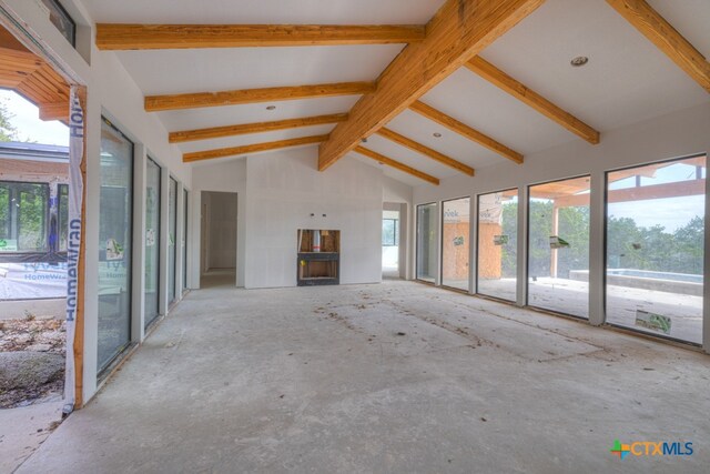 unfurnished living room with beamed ceiling and high vaulted ceiling