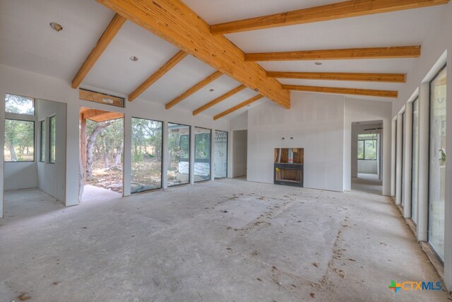 unfurnished living room with beam ceiling and high vaulted ceiling