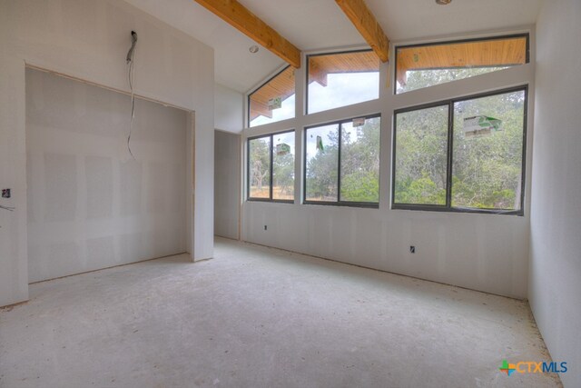 interior space featuring lofted ceiling with beams and multiple windows