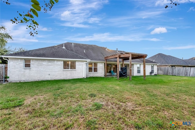 rear view of property with a yard and a pergola