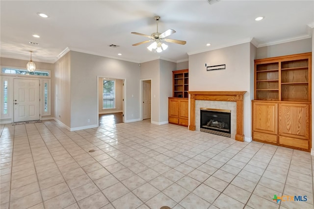 unfurnished living room with ceiling fan, light tile patterned floors, crown molding, and a tiled fireplace