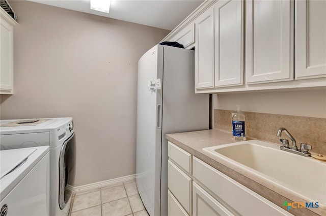 washroom with light tile patterned flooring, cabinets, independent washer and dryer, and sink