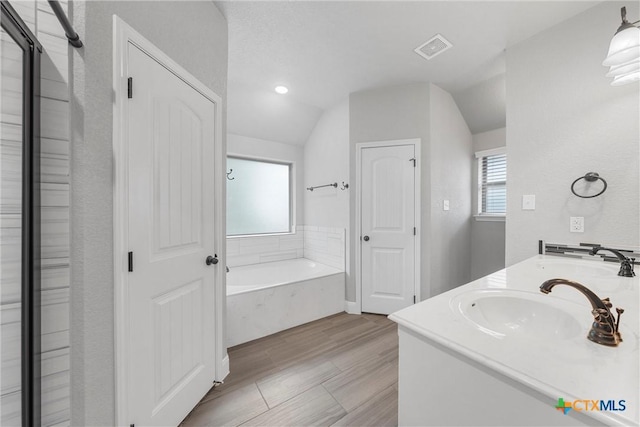 3305 Crystal Ann Dr, Temple, TX 76502 - bathroom featuring a bath, vaulted ceiling, double vanity, recessed lighting, and a closet