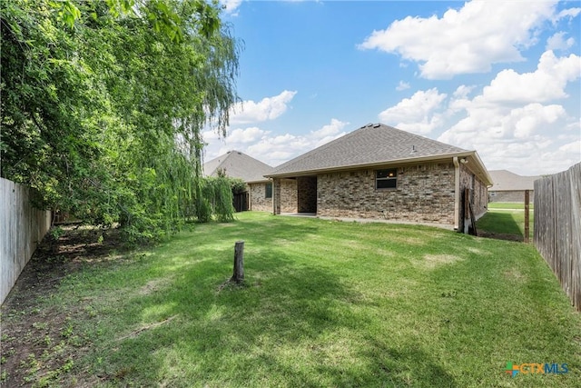 3305 Crystal Ann Dr, Temple, TX 76502 - rear view of house featuring a fenced backyard, a shingled roof, and brick siding
