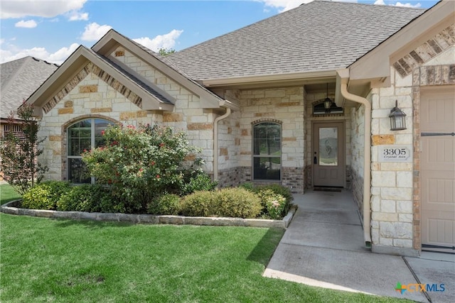 3305 Crystal Ann Dr, Temple, TX 76502 - doorway to property with stone siding, roof with shingles, and a lawn