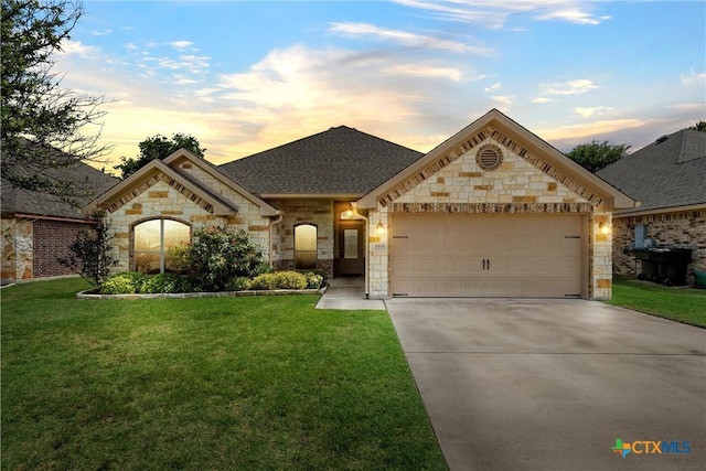 3305 Crystal Ann Dr, Temple, TX 76502 - french country home with stone siding, a garage, concrete driveway, and a yard
