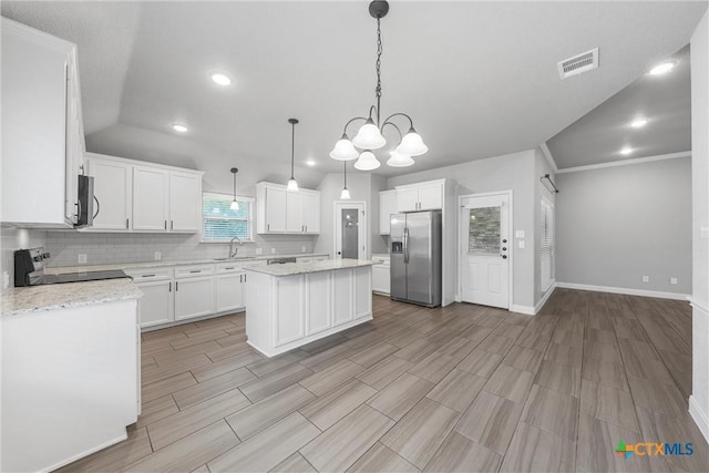 3305 Crystal Ann Dr, Temple, TX 76502 - kitchen with stainless steel appliances, a center island, wood tiled floors, tasteful backsplash, and white cabinets