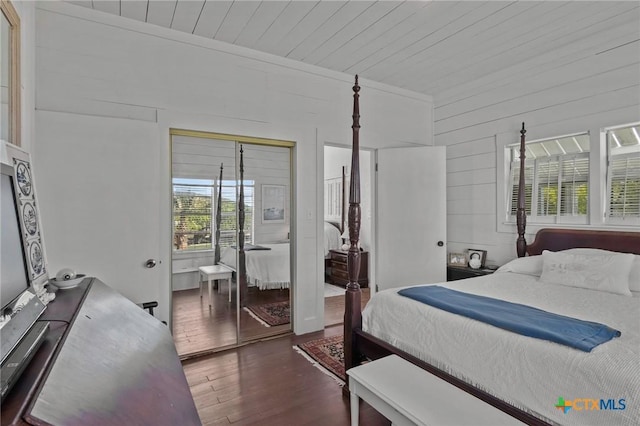 bedroom featuring a closet, multiple windows, wooden ceiling, and wood finished floors