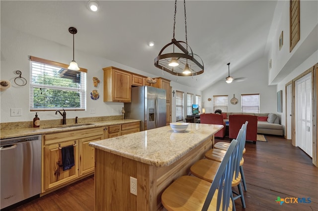 kitchen featuring appliances with stainless steel finishes, dark hardwood / wood-style flooring, sink, vaulted ceiling, and a center island