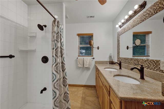 bathroom featuring tasteful backsplash, vanity, a shower with shower curtain, and tile patterned floors