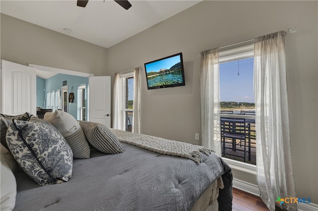 bedroom featuring multiple windows, hardwood / wood-style floors, and ceiling fan