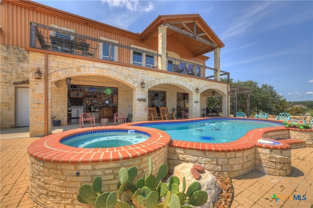 view of pool with a patio and an in ground hot tub