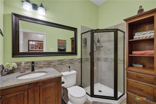 bathroom with toilet, vanity, and an enclosed shower