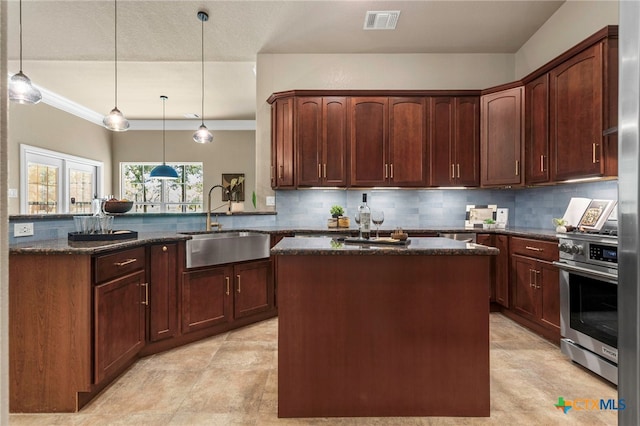 155 Woodrow Center Rd, Kingsbury, TX 78638 - kitchen featuring stainless steel stove, dark stone counters, a peninsula, backsplash, and ornamental molding