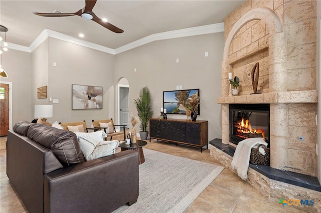 155 Woodrow Center Rd, Kingsbury, TX 78638 - living room with arched walkways, crown molding, a ceiling fan, a tiled fireplace, and recessed lighting