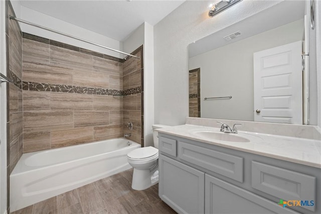 bathroom featuring toilet, vanity,  shower combination, and wood finished floors
