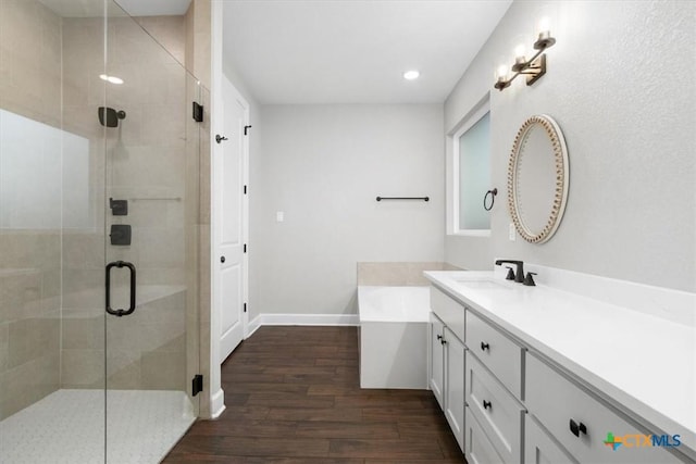 bathroom featuring hardwood / wood-style flooring, vanity, and shower with separate bathtub