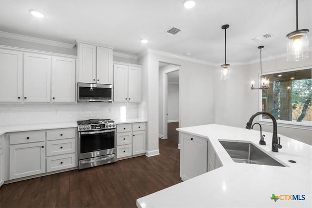 kitchen with white cabinetry, dark hardwood / wood-style flooring, decorative light fixtures, sink, and appliances with stainless steel finishes