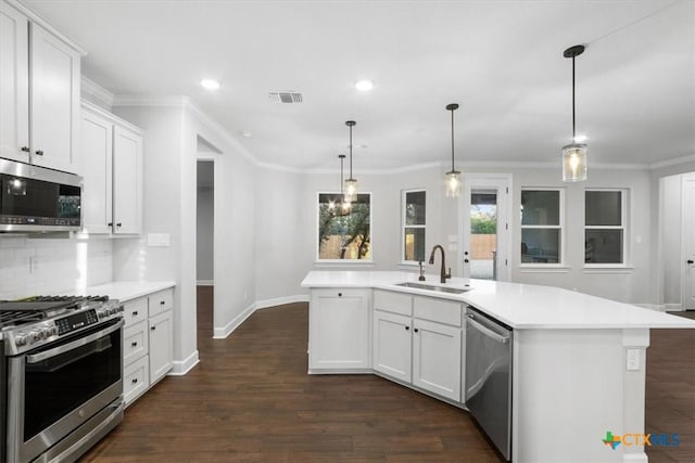 kitchen featuring a center island with sink, sink, pendant lighting, stainless steel appliances, and white cabinets