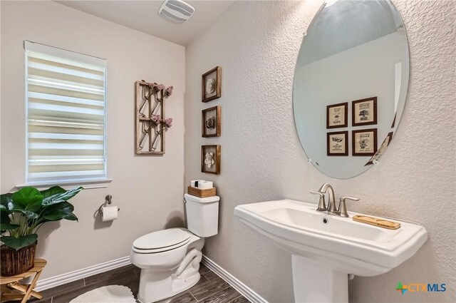 3256 Pablo Cir, Round Rock, TX 78665 - half bathroom with wood finish floors, toilet, baseboards, and a sink
