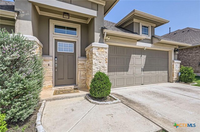 3256 Pablo Cir, Round Rock, TX 78665 - doorway to property featuring stone siding, stucco siding, driveway, and a shingled roof