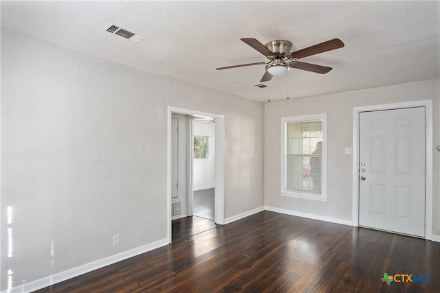 unfurnished room featuring ceiling fan, dark hardwood / wood-style flooring, a textured ceiling, and a wealth of natural light