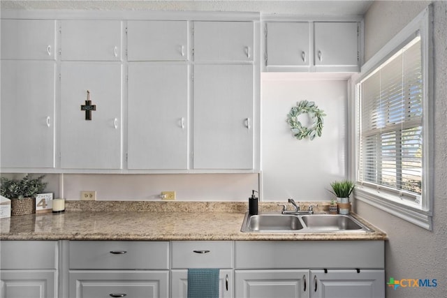 kitchen featuring white cabinets and sink