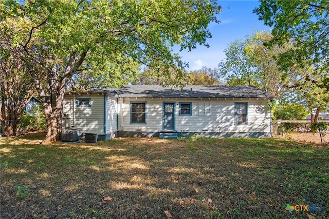 view of front of home with central AC and a front yard