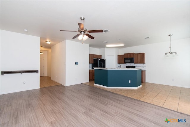 1217 Roanoke Dr, Temple, TX 76504 - kitchen featuring black appliances, light countertops, a ceiling fan, tasteful backsplash, and light wood-style floors