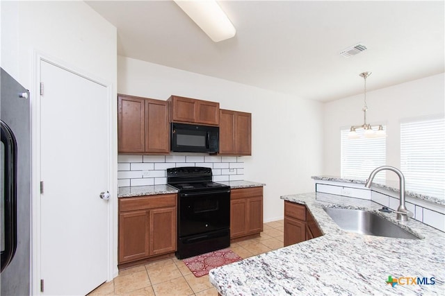 1217 Roanoke Dr, Temple, TX 76504 - kitchen featuring black appliances, brown cabinetry, tasteful backsplash, and hanging light fixtures