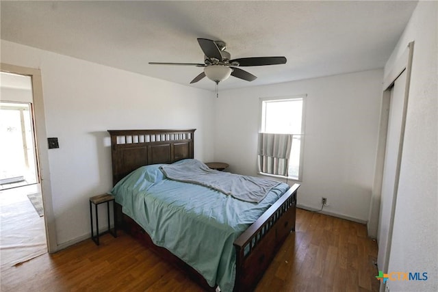 bedroom with dark wood-type flooring, a closet, and ceiling fan