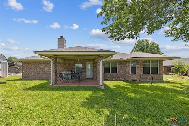 8717 Surrey Ct, Temple, TX 76502 - rear view of house with a patio, a yard, brick siding, a chimney, and a storage shed