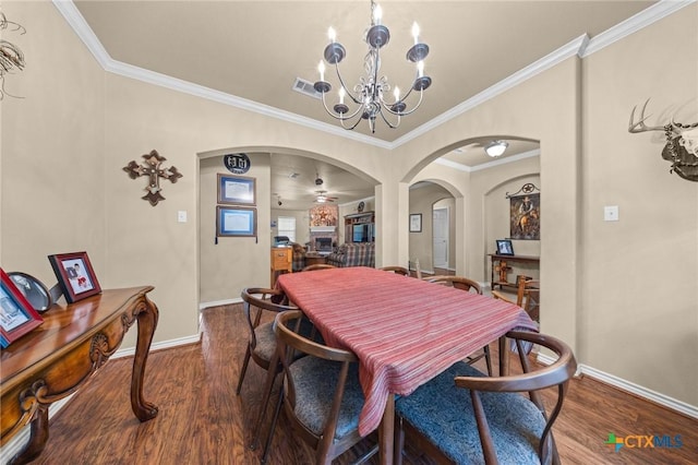 8717 Surrey Ct, Temple, TX 76502 - dining room with arched walkways, dark wood-type flooring, ornamental molding, and a chandelier