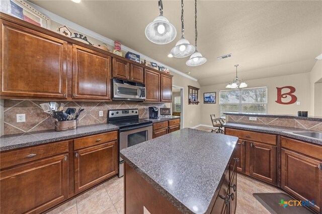 8717 Surrey Ct, Temple, TX 76502 - kitchen with stainless steel appliances, dark countertops, backsplash, ornamental molding, and a chandelier