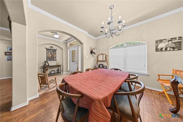 8717 Surrey Ct, Temple, TX 76502 - dining space with arched walkways, wood finished floors, ornamental molding, and a chandelier
