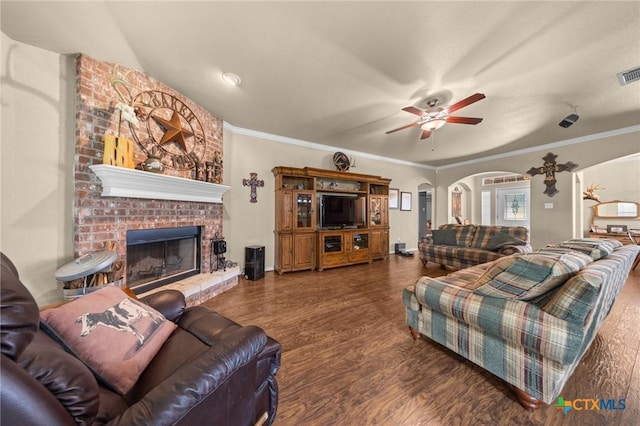 8717 Surrey Ct, Temple, TX 76502 - living area with arched walkways, a ceiling fan, a brick fireplace, wood finished floors, and crown molding