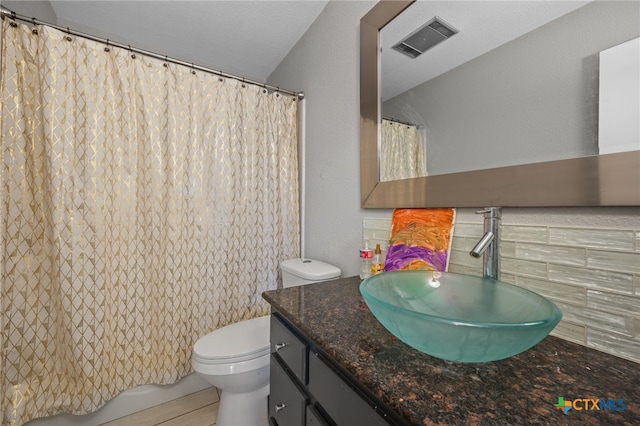 bathroom featuring vanity, toilet, and a textured ceiling